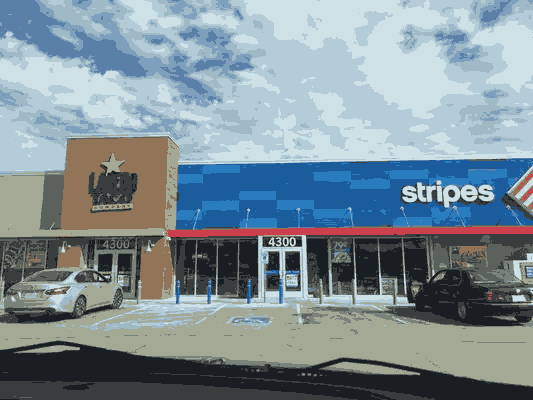 Busy Gas Station With Plenty of Parking Space.